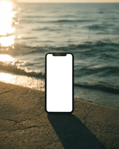 Iphone 12 Mockup Stylish Smartphone On Coastal Pathway With Sea Waves And Golden Hour Glow