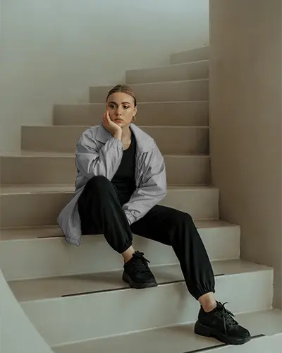 Modern Athleisure Jacket Mockup Woman Wearing Relaxed Fit Windproof Outerwear Sitting On Steps