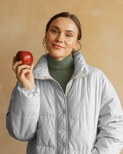 Studio Puffer Jacket Mockup Female Model Smiling Holding Apple Soft Natural Light Fashion Shot