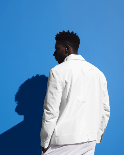 a-person-wearing-varsity-jacket-standing-in-front-of-blue-screen