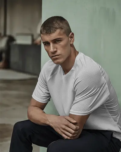 urban-sportswear-jersey-mockup-with-male-model-sitting-against-concrete-wall-in-relaxed-pose-showcasing-front-chest-design-for-custom-branding