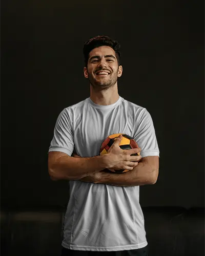 casual-soccer-jersey-mockup-male-model-laughing-holding-ball-black-background-custom-design-display