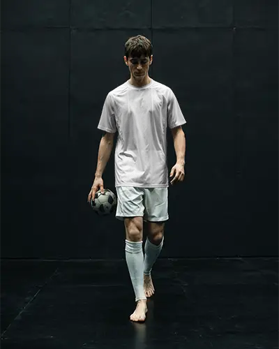 soccer-player-jersey-mockup-minimal-black-background-barefoot-athlete-holding-ball