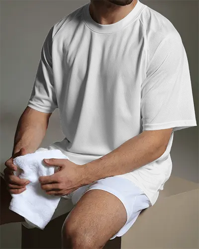 football-jersey-mockup-male-model-sitting-on-bench-in-minimal-studio-lighting-holding-towel-casual-athletic-look
