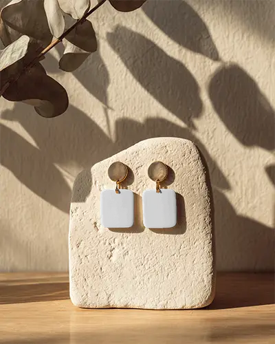 Modern Minimalist Earrings Display On Textured Stone With Natural Shadow Lighting 0163