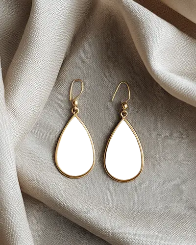 golden-teardrop-earring-mockup-with-green-center-resting-on-soft-cream-fabric-in-natural-light