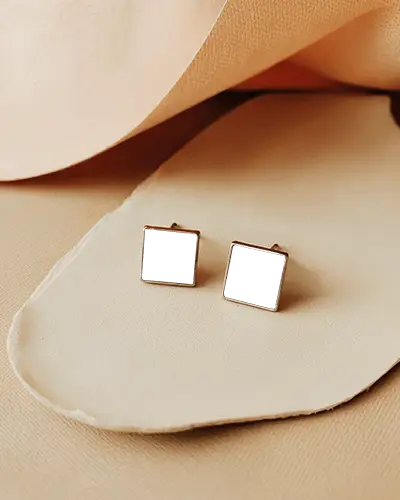 minimalist-square-stud-earring-mockup-with-black-center-on-cream-leather-textured-surface