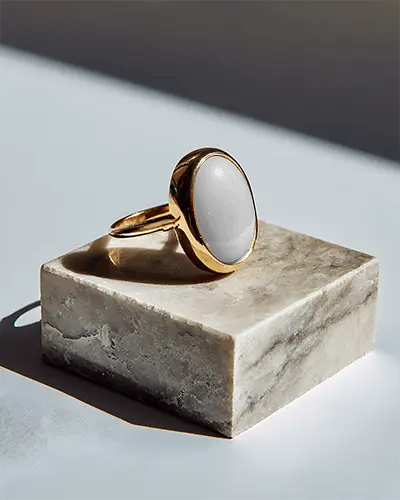 minimalistic-bold-ring-mockup-with-oval-centerpiece-on-marble-base-for-promotional-use