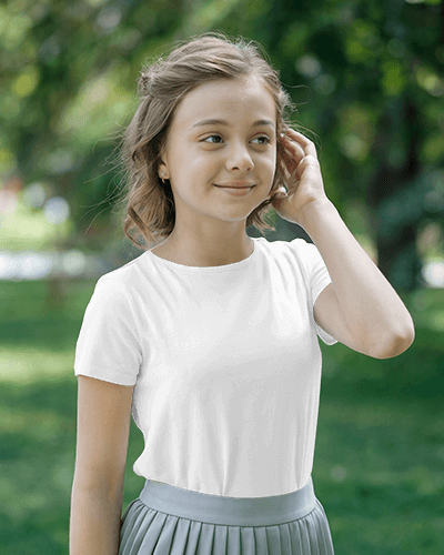 Outdoor Kid T Shirt Mockup Smiling Girl In Bright Yellow Tee With Anime Inspired Design Touching Hair In Green Park Playful And Trendy Look