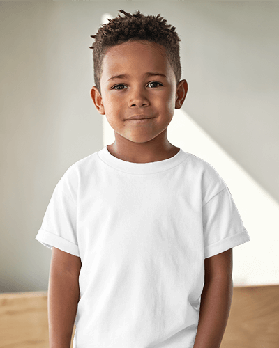 Cute Kid T Shirt Mockup Smiling Boy In Light Pink Tee With Racing Design Standing In Soft Natural Light Modern And Playful Look