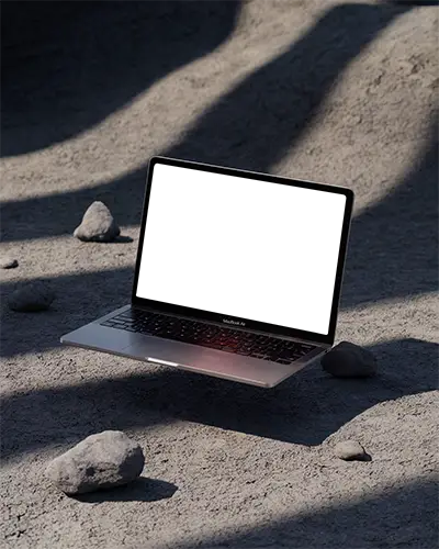 Macbook Air M1 Mockup Hovering Above Dusty Ground With Scattered Rocks And Harsh Directional Shadows Raw And Minimalist Setting