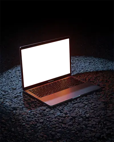 Macbook Air M1 Mockup On Dark Gravel Surface With Vivid Spotlight And Warm Glow Nighttime And Edgy Showcase Style