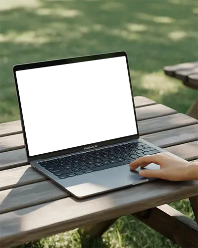Macbook Air M1 On Wooden Picnic Table Outdoors With Hand Interacting Green Grass Background Natural Lighting