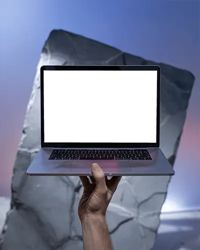 macbook-m1-pro-mockup-held-high-in-front-of-angular-stone-slab-with-soft-sky-gradient