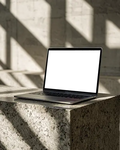 M1 Air Mockup On Textured Stone Block With Sunlit Shadows In Architectural Concrete Space