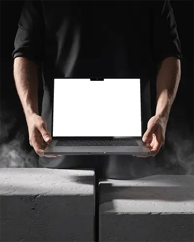 Powerful Macbook M3 Air Mockup Gripped By Hands In Dark Industrial Scene With Rising Smoke