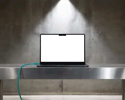 Macbook M3 Pro Mockup On Stainless Table With Focused Overhead Light And Industrial Atmosphere