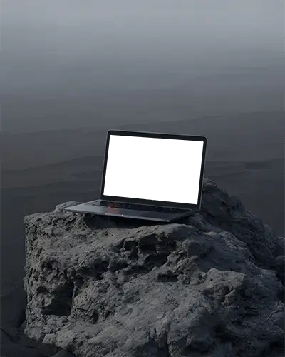 Macbook Pro M1 Mockup On Weathered Rock With Moody Coastal Light And Dark Minimal Atmosphere
