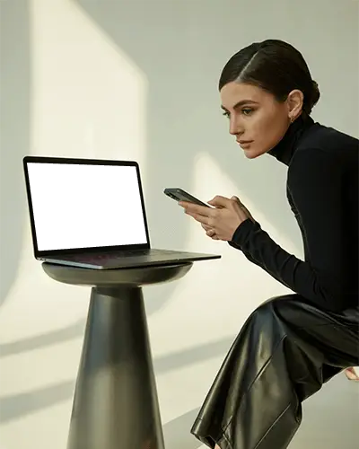 Macbook Pro M1 Mockup With Focused Woman Using Phone In Soft Natural Light And Modern Studio Style