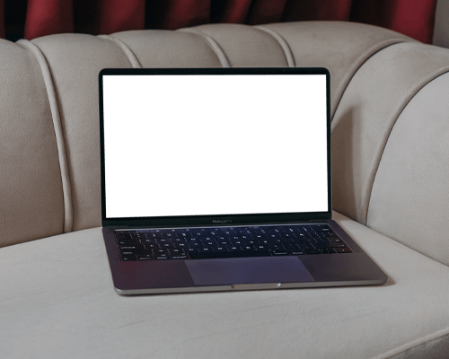 Elegant Macbook Mockup On Luxury Couch In Soft Interior Lighting