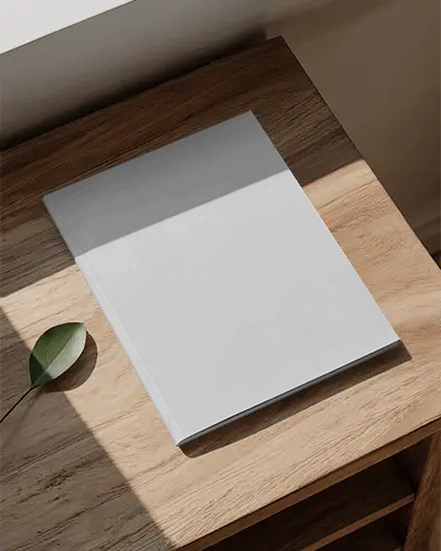 Softcover Magazine Mockup On Wooden Table With Natural Light And Leaf Styling