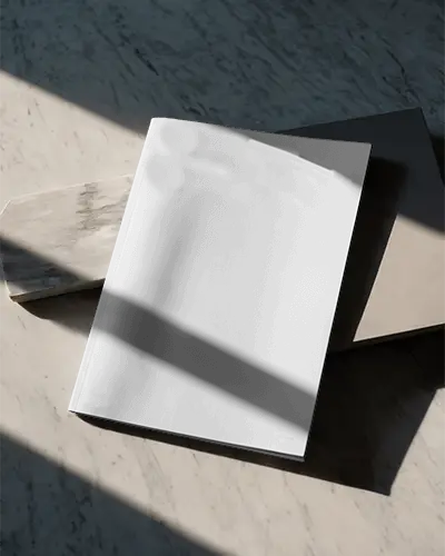 Minimalist Magazine Mockup On Marble Surface With Natural Light And Shadows Angled View