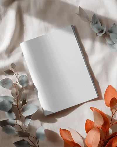 Sleek Square Magazine Mockup With Smooth Texture And Arranged Foliage On Cloth Surface