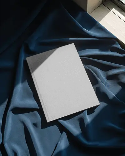 Hardcover Magazine Mockup Lying On Textured Fabric With Natural Light Shadow Play