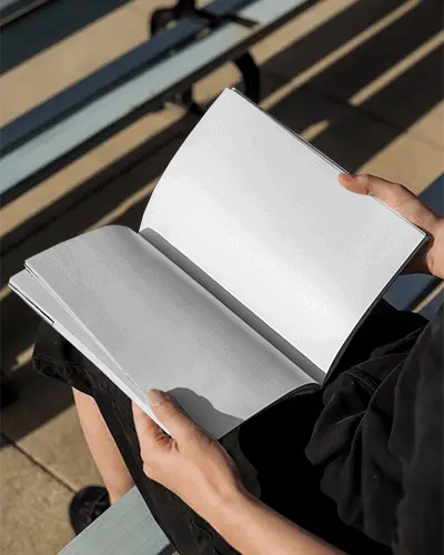 Person Holding Open Blank Magazine Mockup Outdoor Seated On Bench Sunny Day