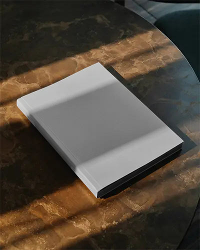 Hardcover Magazine Mockup Placed On Marble Table Under Dramatic Soft Light Shadows