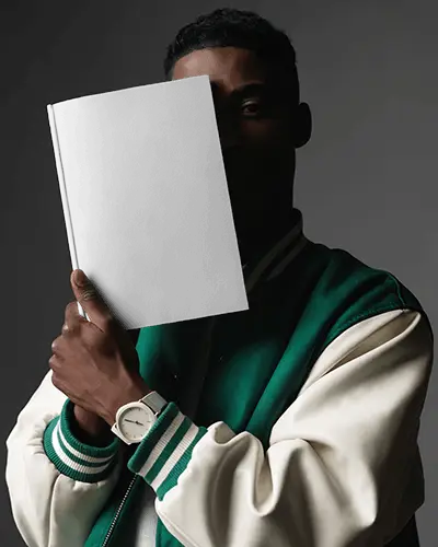 Male Model Holding Blank Magazine Mockup In Dark Portrait Lighting For Modern Fashion Editorial