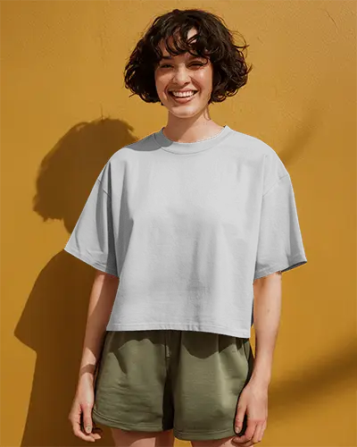 Sunlit Boxy Tshirt Mockup On Smiling Female Model Yellow Wall Background