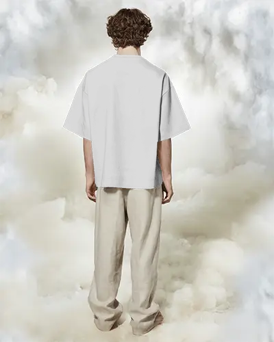 Boxy Blank White Round Neck Unisex T Shirt Mockup Back View On Male Model Cloudy Dreamlike Background Relaxed Pose Soft Light Studio Vibe
