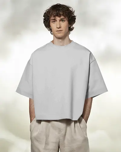 Boxy Blank White Round Neck Unisex T Shirt Mockup Front View On Male Model Soft Cloudy Background Hands In Pockets Casual And Airy Vibe