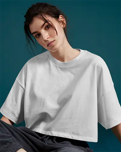 White Oversized Crop Tshirt Mockup Seated Female Model Loose Fit Soft Studio Lighting Teal Background