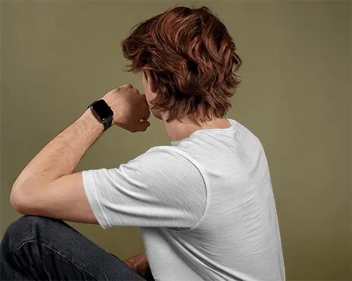 Seated Backview Tshirt Mockup Male Model With Wavy Hair And Smartwatch