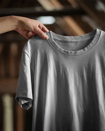 Natural Light Holding Tshirt Mockup Close Up Of Hand Holding Blank Shirt In Wooden Loft With Sunlight Texture Details