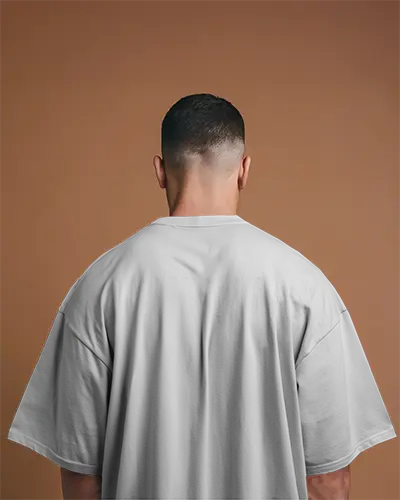 Studio Back View Tshirt Mockup Male Model Wearing Oversized White Tee On Warm Backdrop 