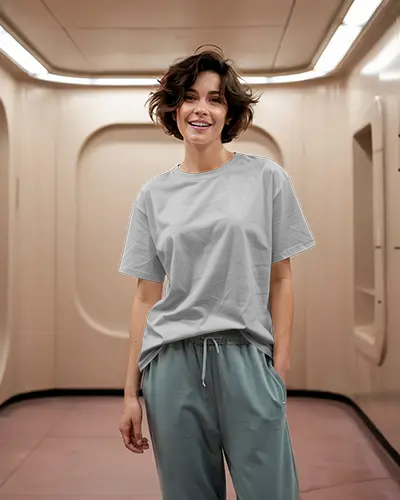 Indoor T Shirt Mockup Female Model In Relaxed Fit Tee And Joggers Smiling In Futuristic Hallway Casual And Playful Vibe