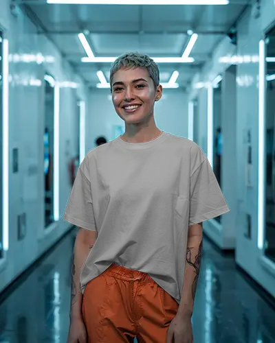 Futuristic Hallway T Shirt Mockup Female Model In Relaxed Fit Tee And Orange Pants Smiling Under Neon Lights Bold And Modern Look