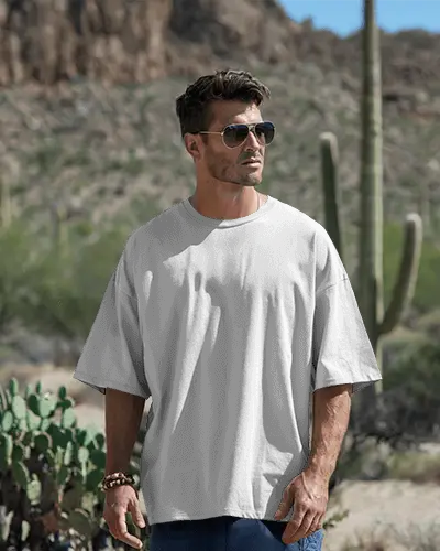 Desert Outdoor Tshirt Mockup With Male Model In Oversized White Tee Among Cactus And Rocky Background