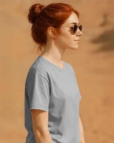 Side View Tshirt Mockup Female Model With Red Hair And Sunglasses On Warm Sandy Backdrop Sleeve And Front Print Visible Natural Lighting