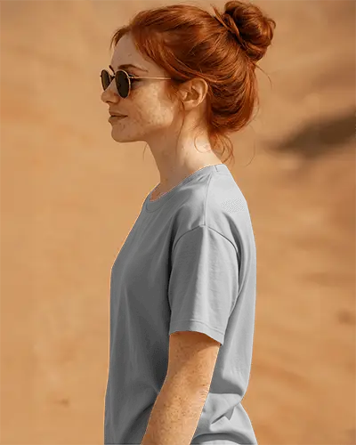 Side Profile Tshirt Mockup Female Model In Sunglasses On Sandy Beige Background Front And Sleeve Print Visible Natural Sunlit Style