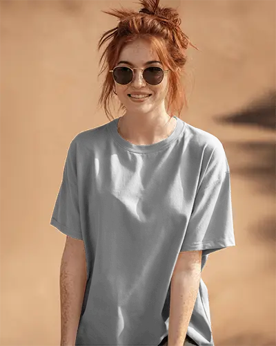 Front View Tshirt Mockup Female Model In Sunglasses On Sandy Beige Background Front And Sleeve Print Visible Natural Sunlit Style