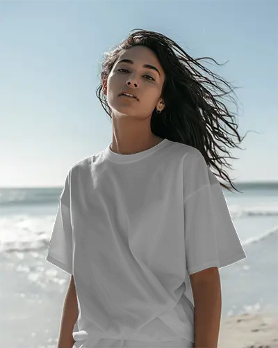 Sunlit Beachside Tshirt Mockup Female Model With Windblown Hair Gazing Ahead Relaxed Vibe With Soft Natural Light And Ocean Backdrop 01245