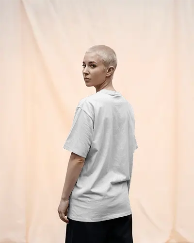 Edgy And Clean Tshirt Mockup Featuring Woman In Back Facing Pose Against Draped Peach Fabric Background