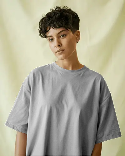 Neutral Backdrop T Shirt Mockup Female Model With Short Curly Hair Wearing Oversized Grey Tee Minimalist Studio Look