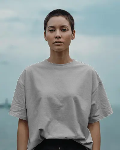 Outdoor T Shirt Mockup Female Model With Buzzcut In Grey Tee Facing Forward Under Cloudy Sky Minimalist Style