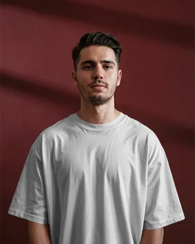 Sunlit Interior Tshirt Mockup Male Model Standing Confidently In Tee Against Dark Maroon Wall