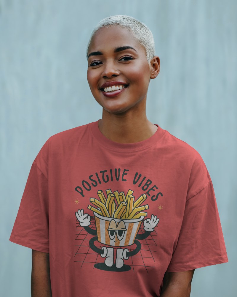 Outdoor T Shirt Mockup Smiling Female Model With Platinum Buzzcut In Grey Tee Standing Against Light Blue Wall